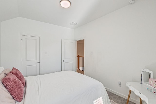 carpeted bedroom with lofted ceiling