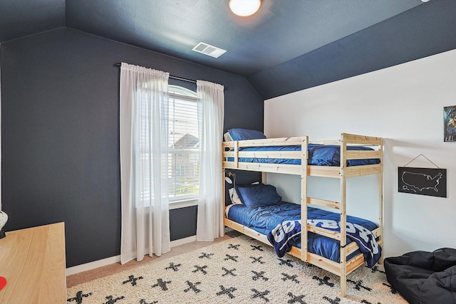 bedroom with vaulted ceiling and carpet floors