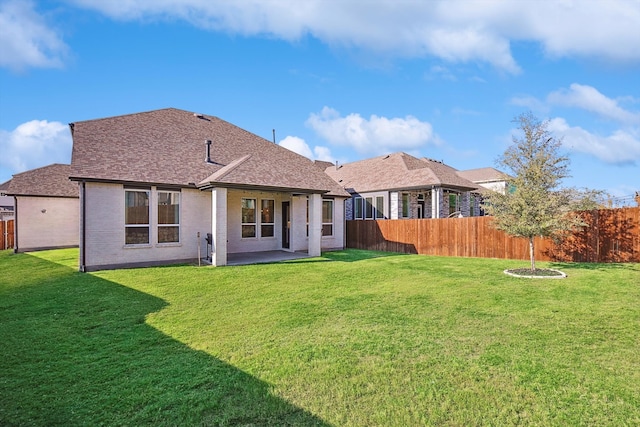 rear view of property featuring a patio area and a yard