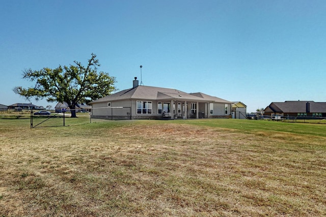 rear view of house featuring a lawn