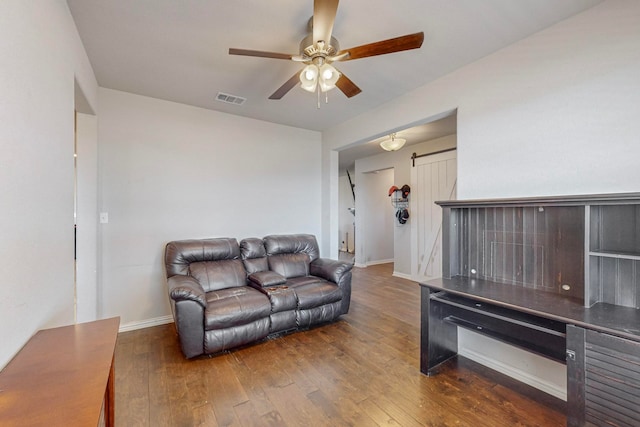 living room with dark wood-type flooring and ceiling fan