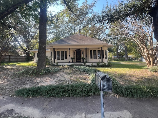 view of front of house featuring covered porch and a front yard