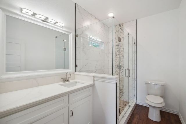 bathroom featuring vanity, hardwood / wood-style flooring, toilet, and walk in shower