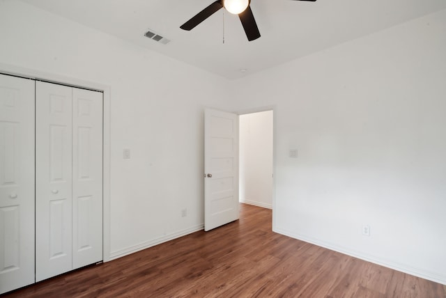 unfurnished bedroom featuring a closet, dark hardwood / wood-style floors, and ceiling fan