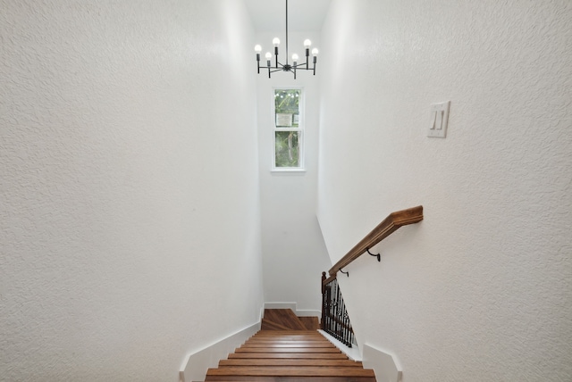 stairs with a notable chandelier