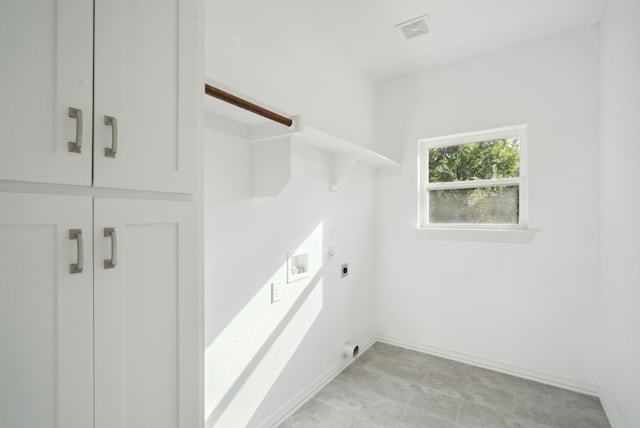 laundry room with cabinets, hookup for an electric dryer, hookup for a washing machine, and light tile patterned floors