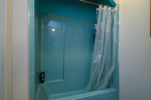 bathroom with shower / bath combo with shower curtain