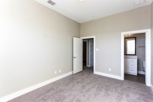 unfurnished bedroom with light carpet and ensuite bathroom