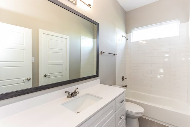 full bathroom featuring vanity, tiled shower / bath combo, and toilet