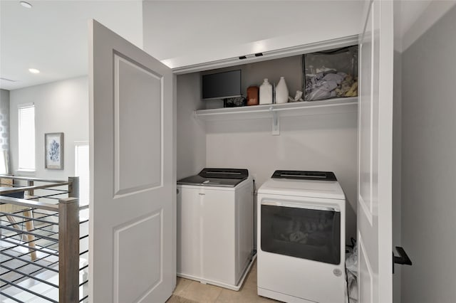 washroom with washer and clothes dryer and light tile patterned floors