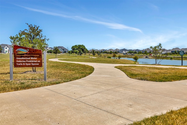 view of property's community featuring a yard and a water view