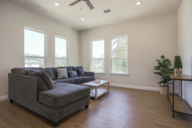 living room featuring ceiling fan and dark hardwood / wood-style flooring