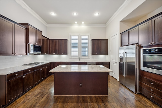 kitchen with dark brown cabinetry, stainless steel appliances, a kitchen island, and dark hardwood / wood-style flooring