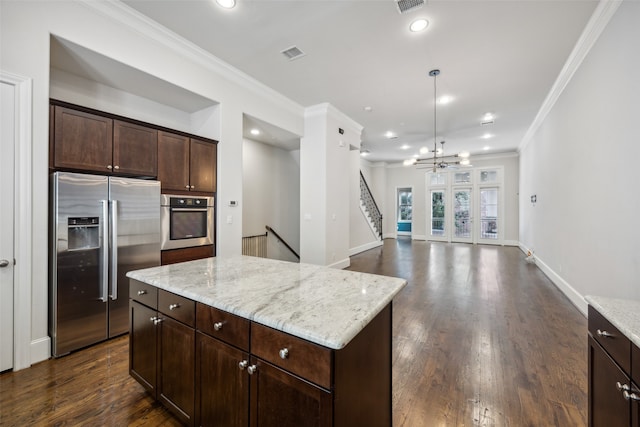 kitchen featuring crown molding, appliances with stainless steel finishes, a center island, and dark hardwood / wood-style floors