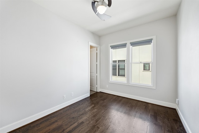 empty room featuring dark wood-type flooring and ceiling fan