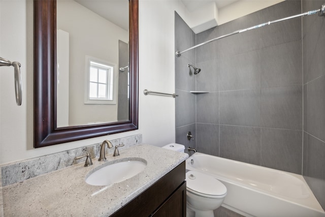 full bathroom featuring toilet, tiled shower / bath, and vanity