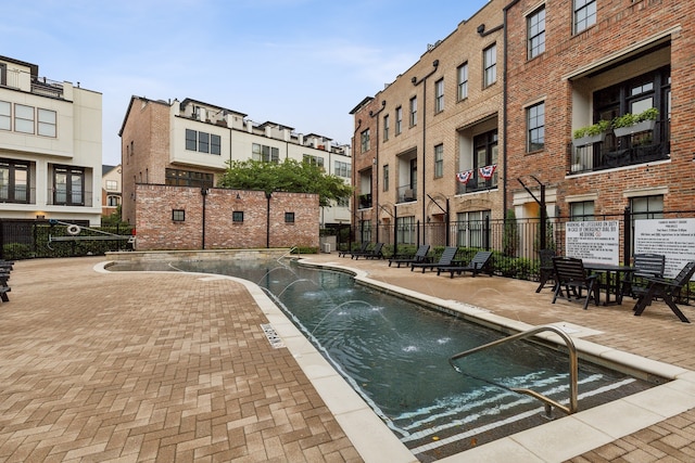 view of swimming pool featuring pool water feature and a patio area