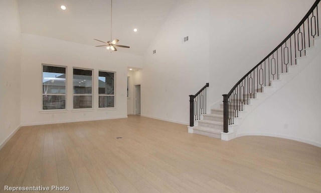 2414 Plumeria Ln, Celina, TX 75009 - unfurnished living room with baseboards, stairs, ceiling fan, high vaulted ceiling, and light wood finished floors
