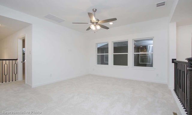 empty room featuring light colored carpet and ceiling fan