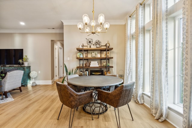 dining room with crown molding, an inviting chandelier, and light wood-type flooring