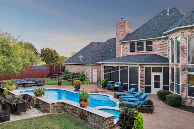 view of pool with a patio area, an in ground hot tub, and a sunroom