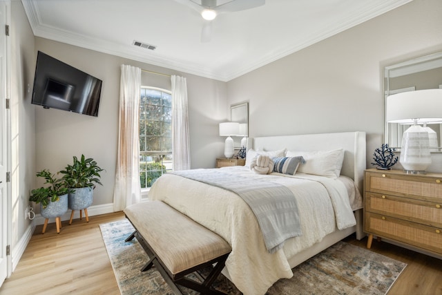 bedroom with crown molding, light wood-type flooring, and ceiling fan