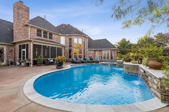 view of swimming pool featuring pool water feature, a patio, and a sunroom