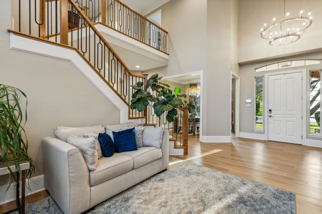 foyer entrance featuring a chandelier, hardwood / wood-style flooring, and a towering ceiling