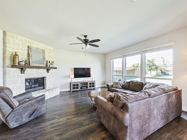 living room featuring dark wood-type flooring, a fireplace, and ceiling fan