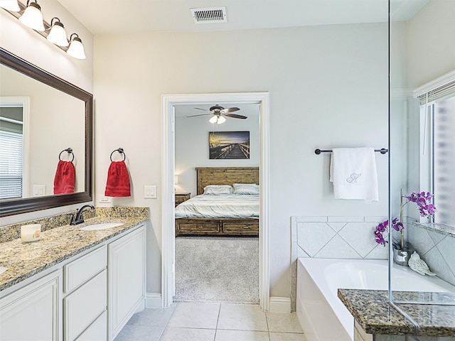 bathroom with vanity, a tub, tile patterned floors, and ceiling fan