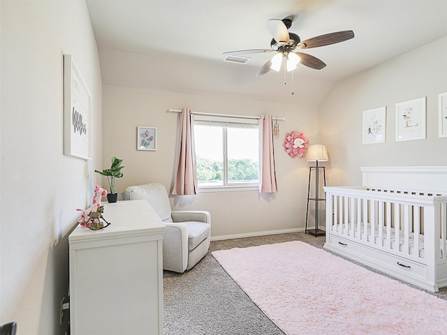 bedroom featuring ceiling fan, light carpet, vaulted ceiling, and a nursery area