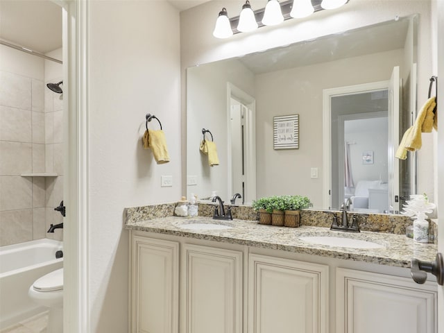 full bathroom featuring vanity, tiled shower / bath combo, and toilet