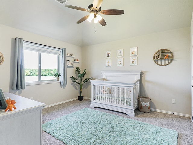 bedroom featuring ceiling fan, vaulted ceiling, light colored carpet, and a nursery area