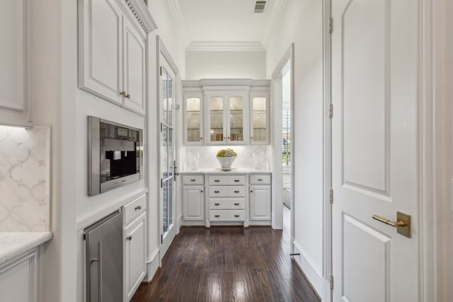 kitchen with white cabinetry, crown molding, tasteful backsplash, and dark wood-type flooring