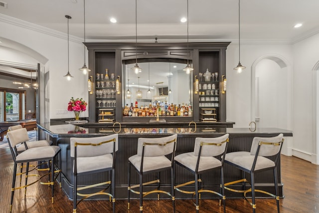 bar with crown molding, dark hardwood / wood-style floors, and pendant lighting