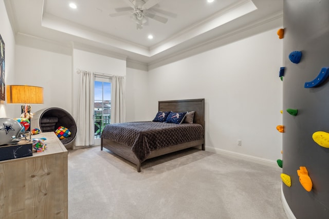 bedroom featuring ceiling fan, a raised ceiling, crown molding, and light colored carpet