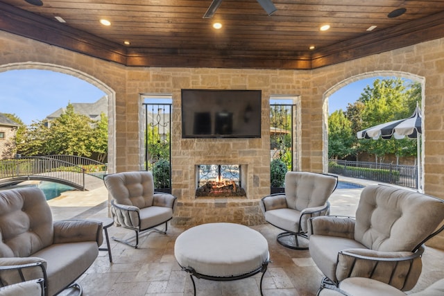 view of patio featuring a fenced in pool and an outdoor living space with a fireplace