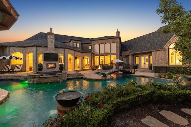 view of swimming pool featuring an in ground hot tub, a patio area, and french doors