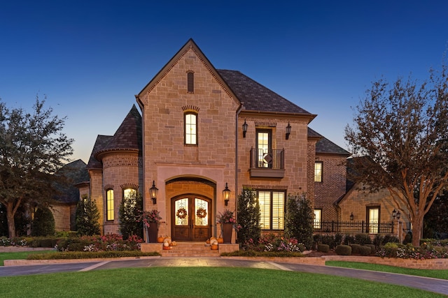 french country home with french doors and a balcony