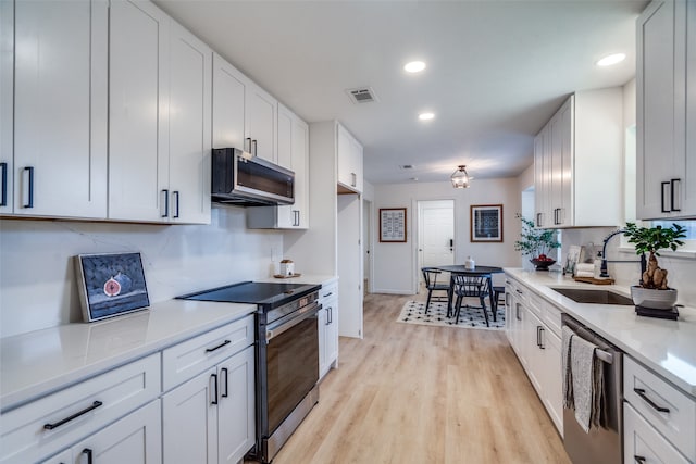 kitchen with white cabinetry, stainless steel appliances, and sink