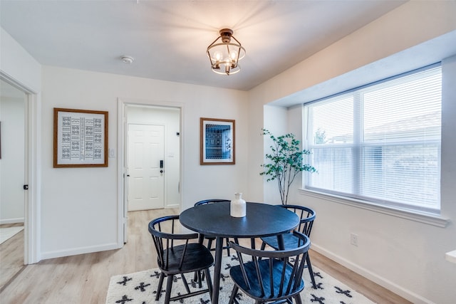 dining space with a notable chandelier and light wood-type flooring