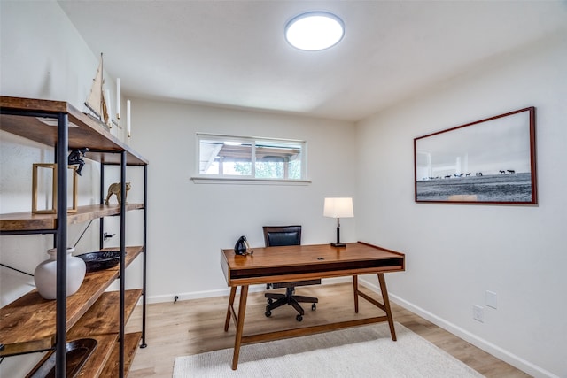 home office with light hardwood / wood-style flooring