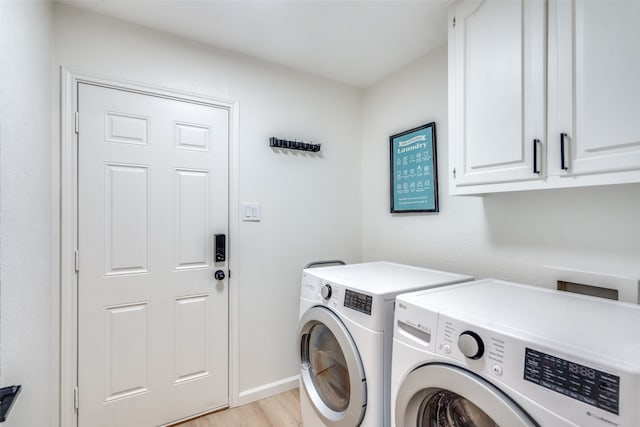 clothes washing area with cabinets, washer and clothes dryer, and light wood-type flooring