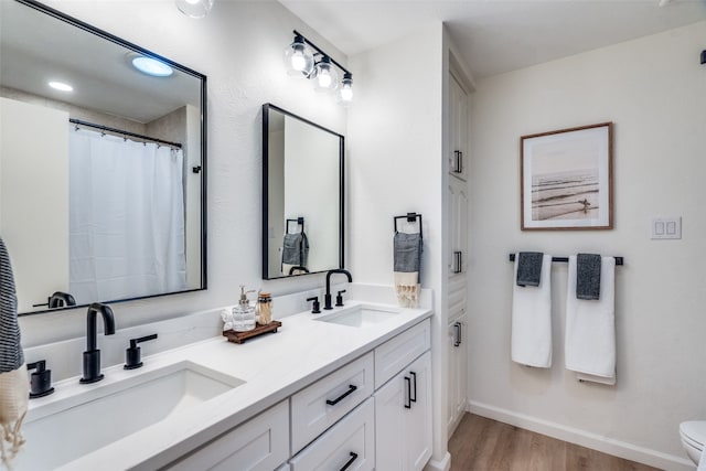 bathroom featuring vanity, hardwood / wood-style floors, and toilet