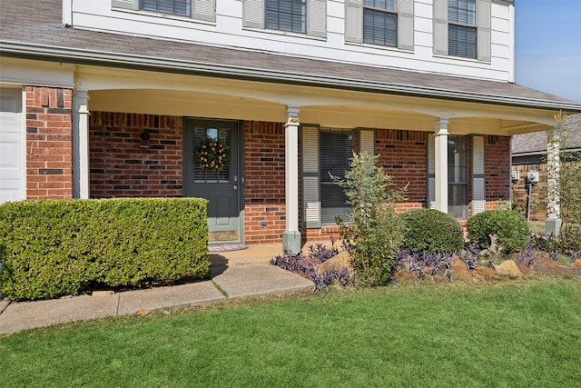 doorway to property featuring a lawn and a porch