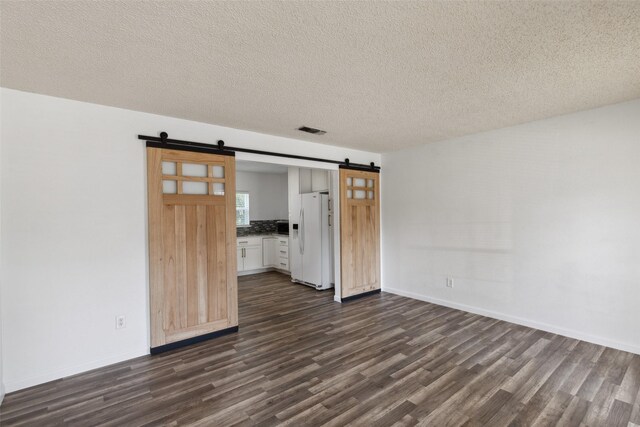 unfurnished living room featuring a textured ceiling, hardwood / wood-style flooring, a wealth of natural light, and ceiling fan