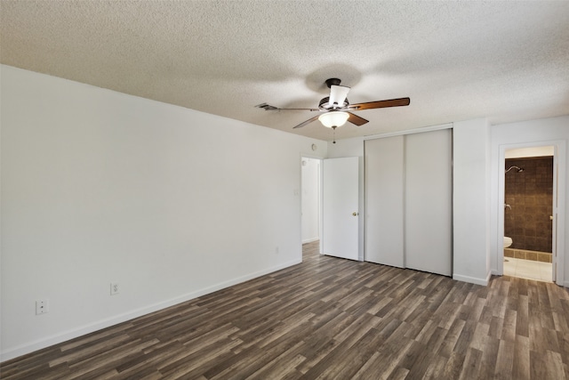 unfurnished bedroom with ceiling fan, dark hardwood / wood-style flooring, and a textured ceiling