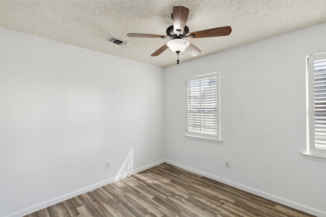 empty room with hardwood / wood-style flooring, ceiling fan, and a textured ceiling