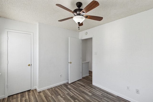 unfurnished bedroom featuring a textured ceiling, dark hardwood / wood-style flooring, and ceiling fan