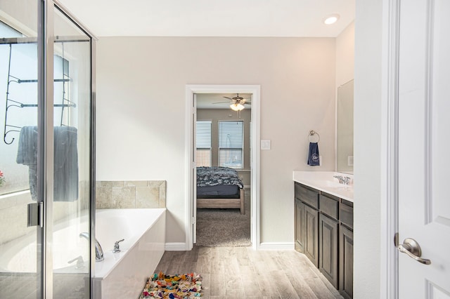 bathroom featuring vanity, hardwood / wood-style flooring, independent shower and bath, and ceiling fan